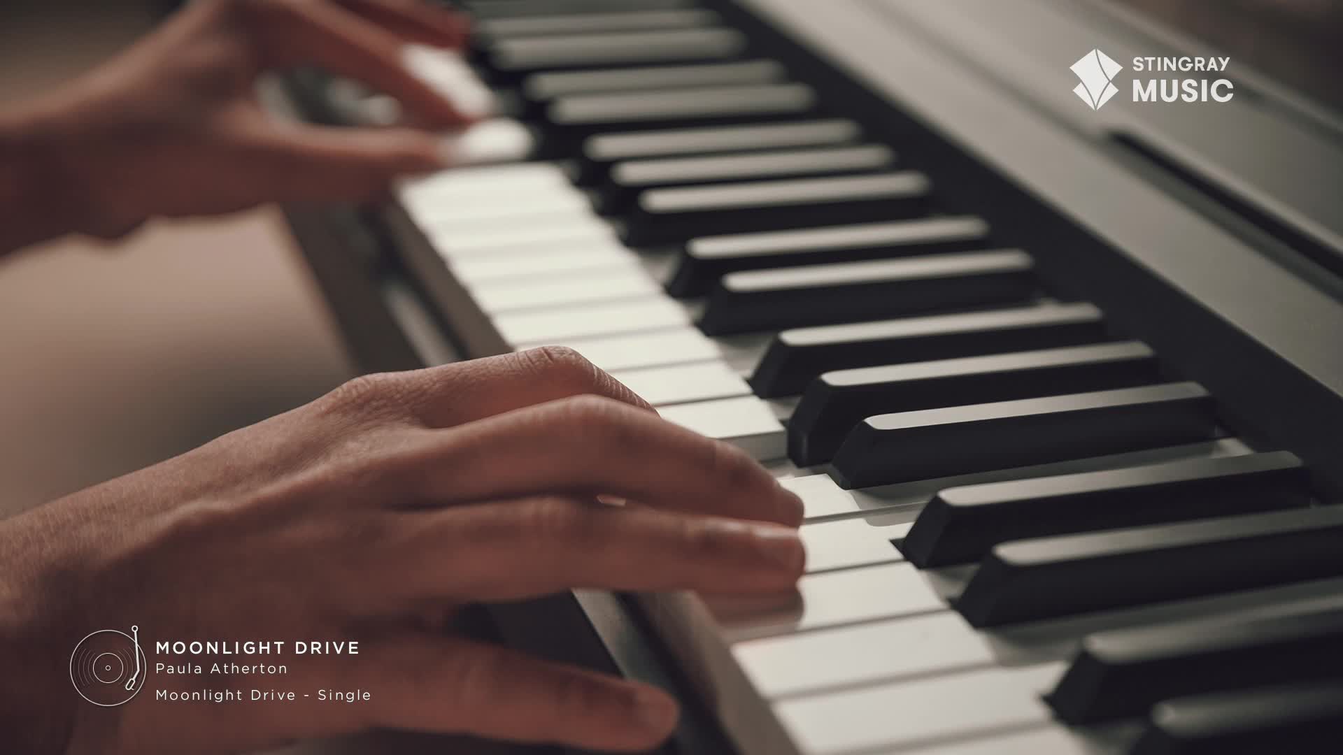 Fingers dance across the piano keys, creating the smooth jazz sounds of Paula Atherton's "Moonlight Drive." This Canadian artist's single is playing, the Stingray Music logo subtly visible.