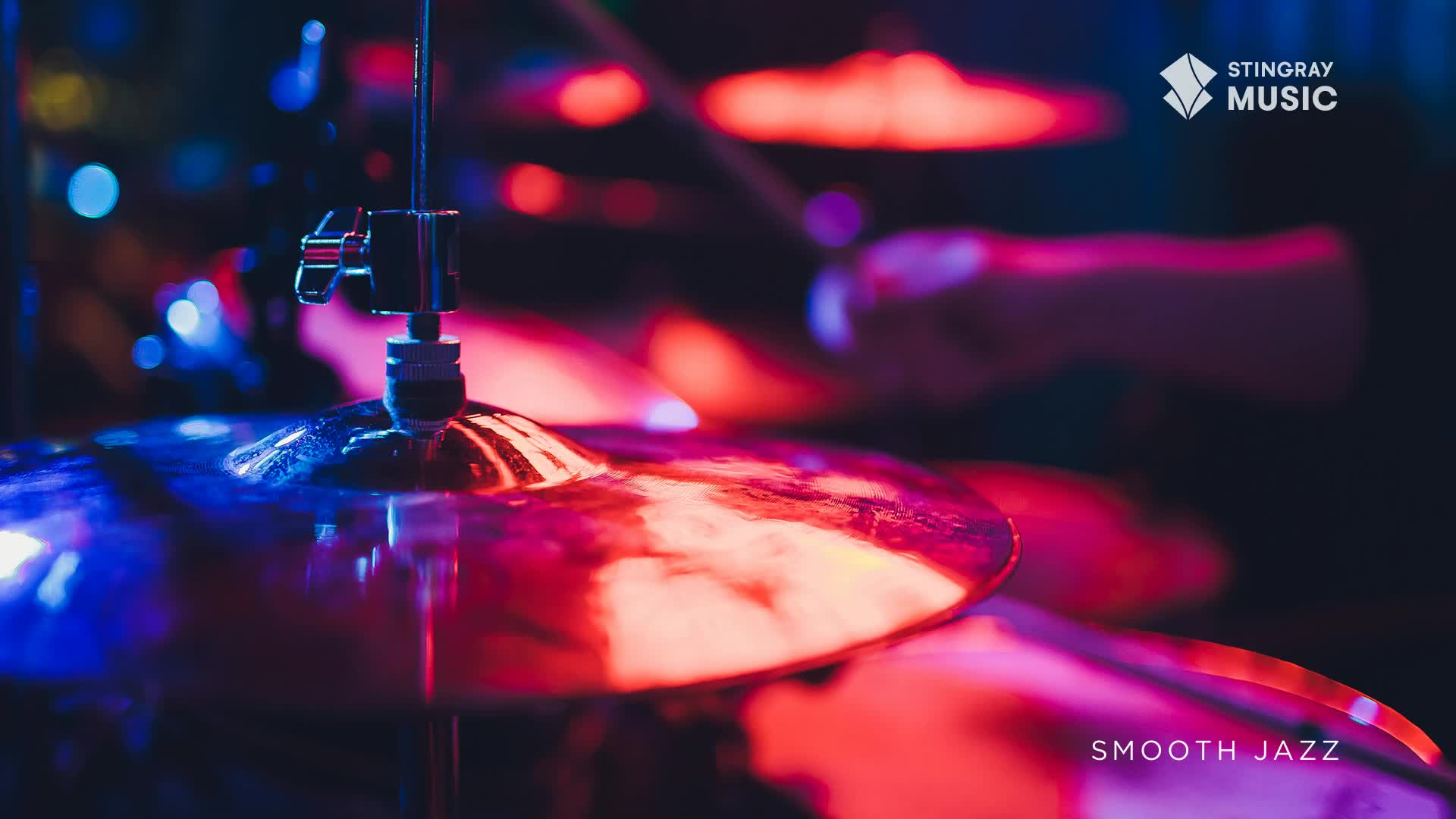 A drumstick descends, poised to strike a cymbal bathed in red and blue light. The smooth jazz soundtrack from Stingray Music fills the air.