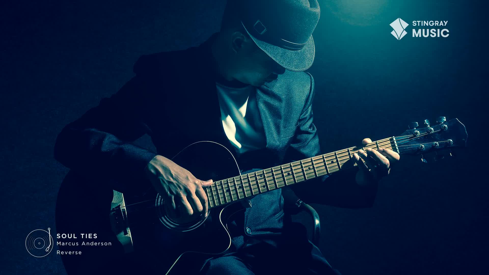 A man in a fedora and jacket plays an acoustic guitar, his fingers expertly navigating the fretboard. The smooth jazz melody fills the air, a signature sound from Stingray Music in Canada.