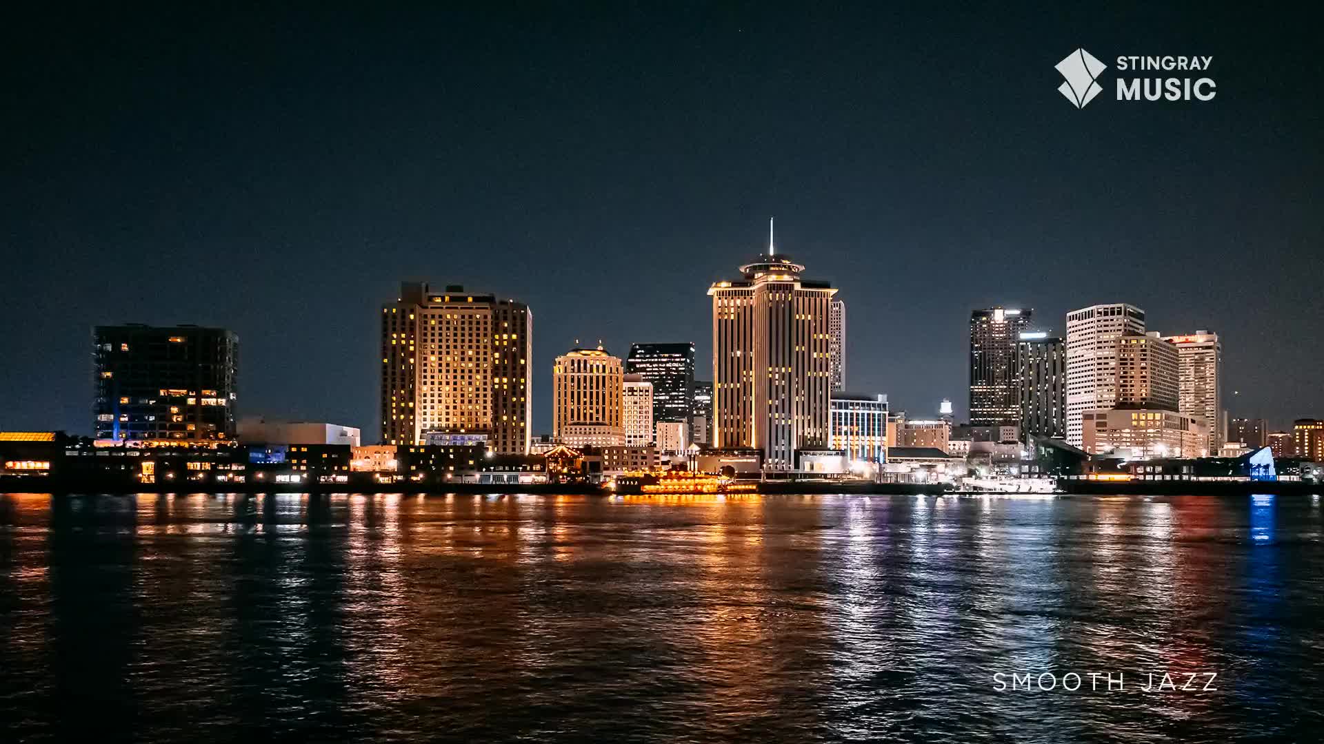 The city skyline glows against the dark Canadian night, its lights reflecting on the water. A Stingray Music logo appears in the corner, hinting at the smooth jazz soundtrack playing.
