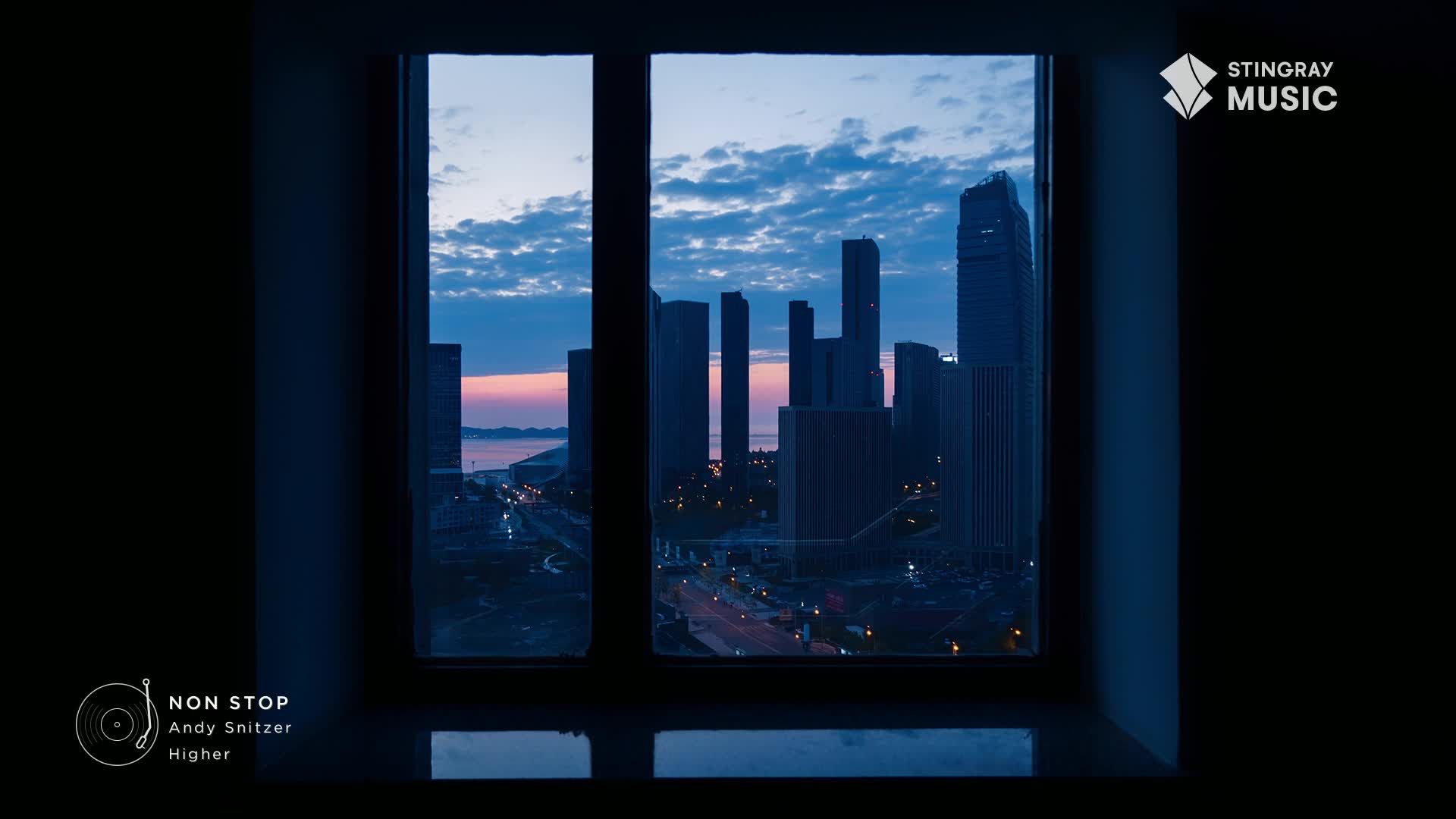 The city skyline stretches out under a twilight sky, lights beginning to twinkle on the streets below. A gentle breeze rustles the clouds as the last hint of pink fades from the horizon.