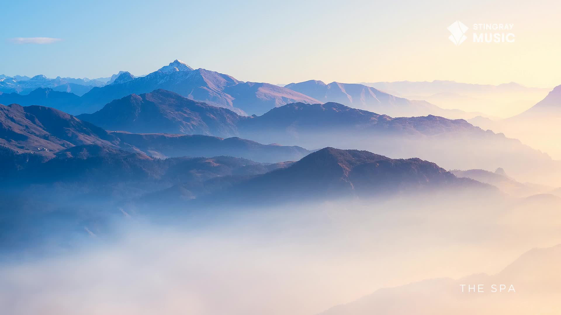 Layers of mountains fade into the distance, shrouded in a soft, ethereal mist. The Stingray The Spa logo sits in the top right corner, a reminder of the tranquility of the Canadian landscape.
