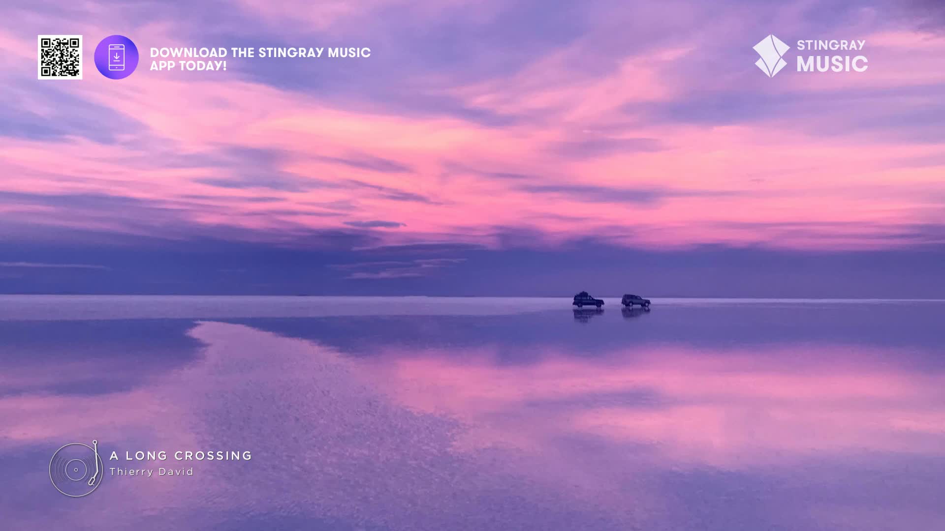 Two small vehicles drive across a vast, reflective surface, mirroring the pink and purple sky above. The scene evokes a sense of calm, like something you might hear on Stingray Music from Canada.
