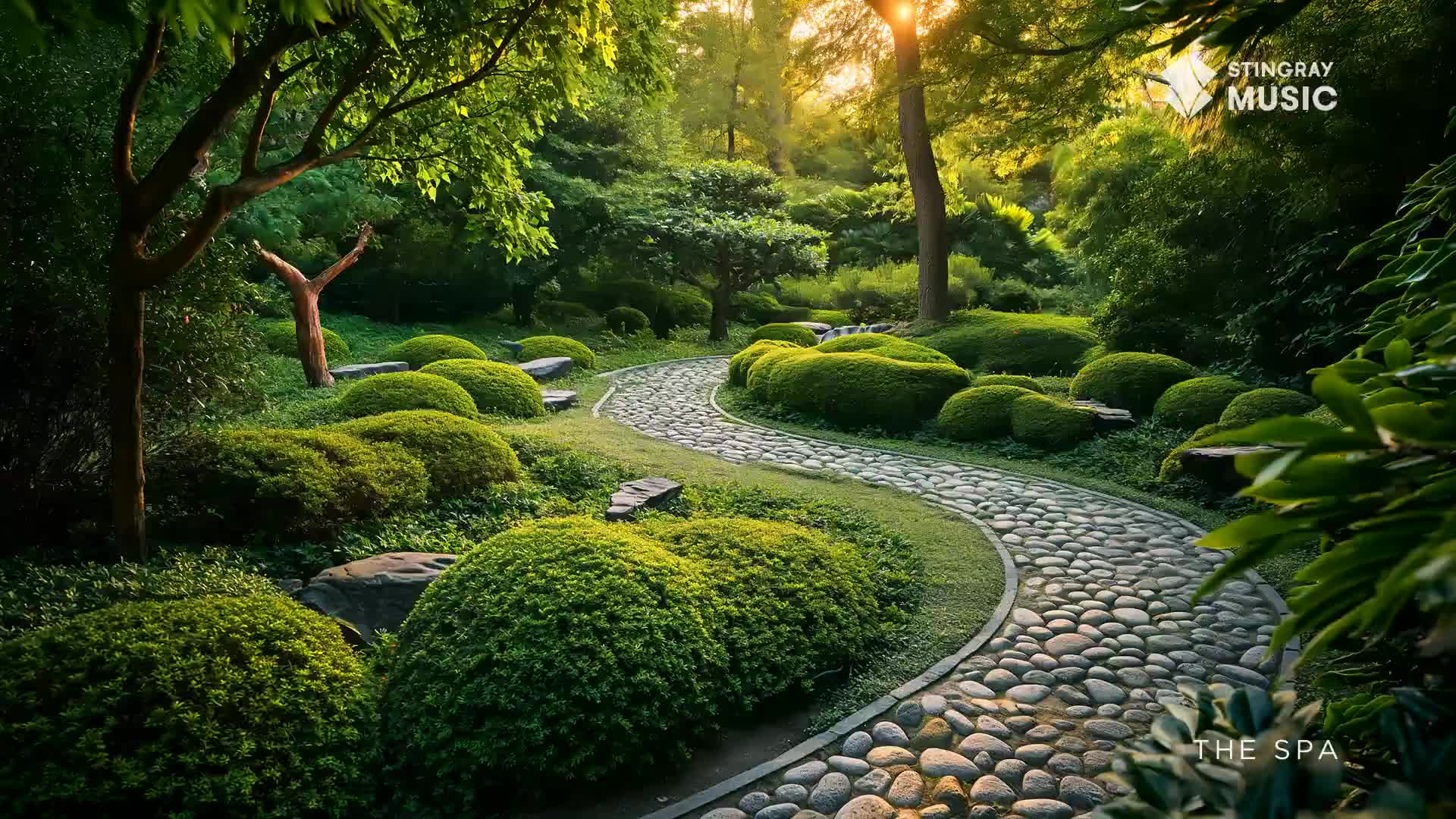 Sunlight filters through the trees onto a winding stone path in a meticulously maintained garden, reminiscent of a tranquil spa in Canada. Lush, rounded bushes flank the walkway, creating a serene and inviting atmosphere.