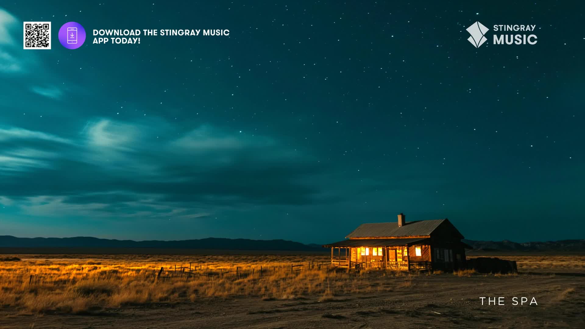 A remote cabin glows warmly under a vast, star-dusted Canadian sky. The dry grass rustles in the evening breeze, a stark contrast to the stillness of the mountains in the distance.