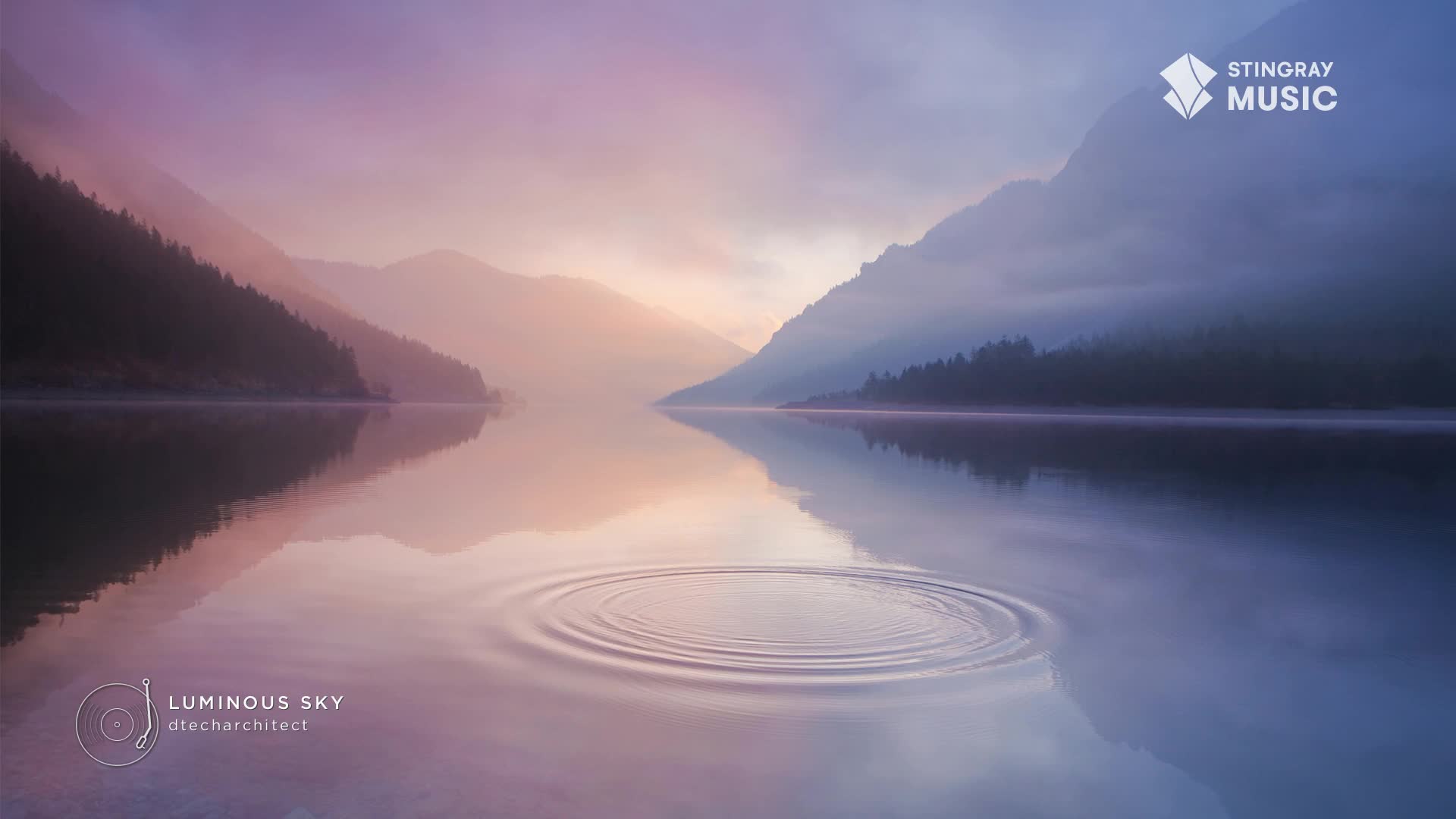 The water's surface ripples outward from a central point, mirroring the soft, pastel hues of the sky. Mountains shrouded in mist rise on either side of the tranquil lake, their reflections appearing on the still water. The water's surface ripples outward from a central point, mirroring the soft, pastel hues of the sky. Mountains shrouded in mist rise on either side of the tranquil lake, their reflections appearing on the still water.
