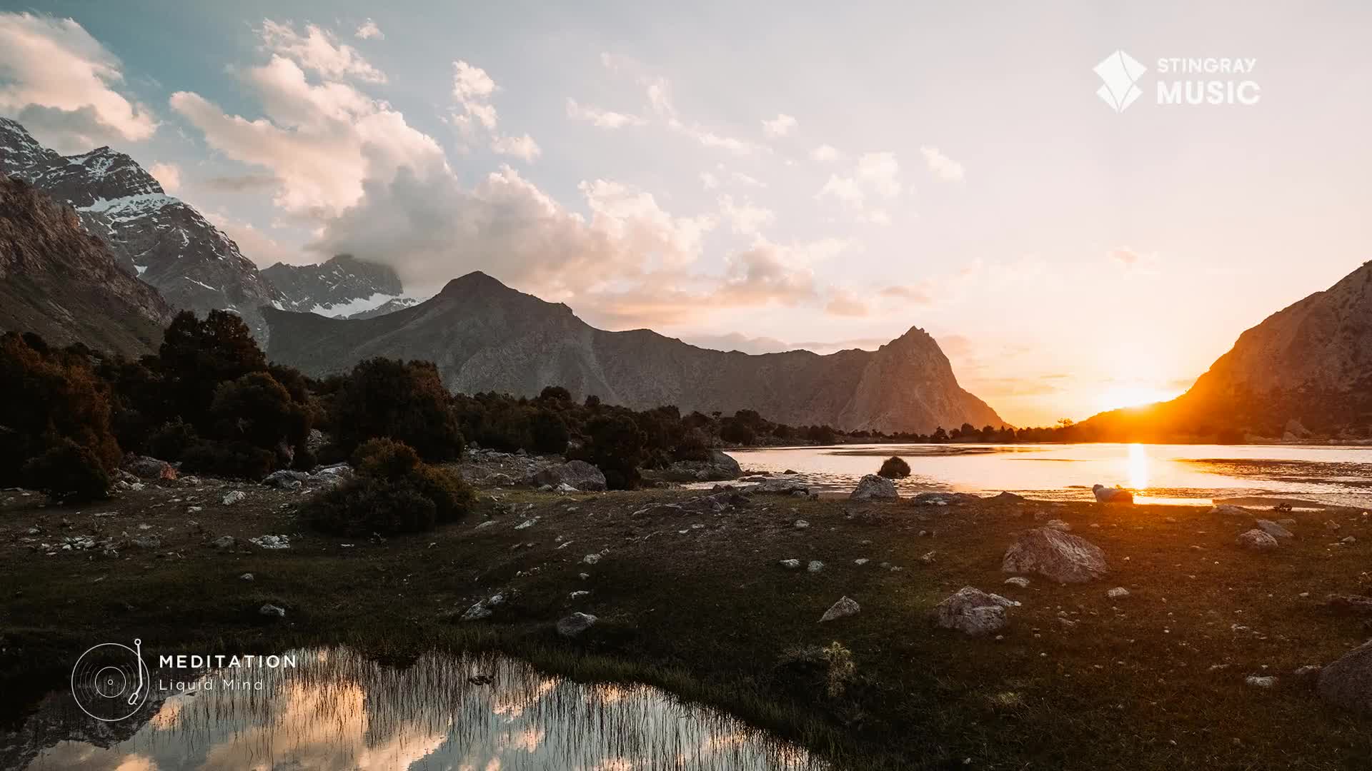 The sun dips behind jagged peaks, casting a warm glow across a still lake.  This is the kind of quiet beauty you find far from the city, a perfect moment for reflection.