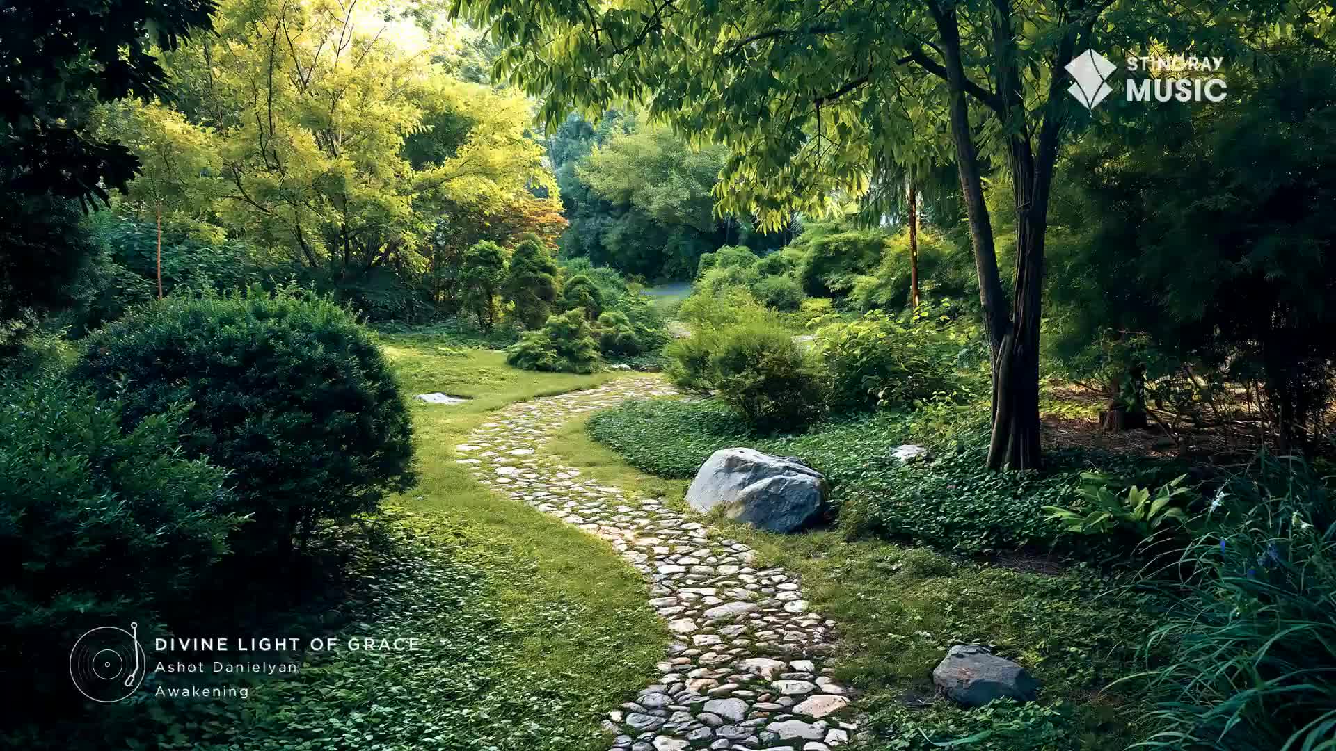 Sunlight filters through the trees onto a winding stone path in this Canadian garden. Lush greenery surrounds the path, with a large grey boulder resting beside it.