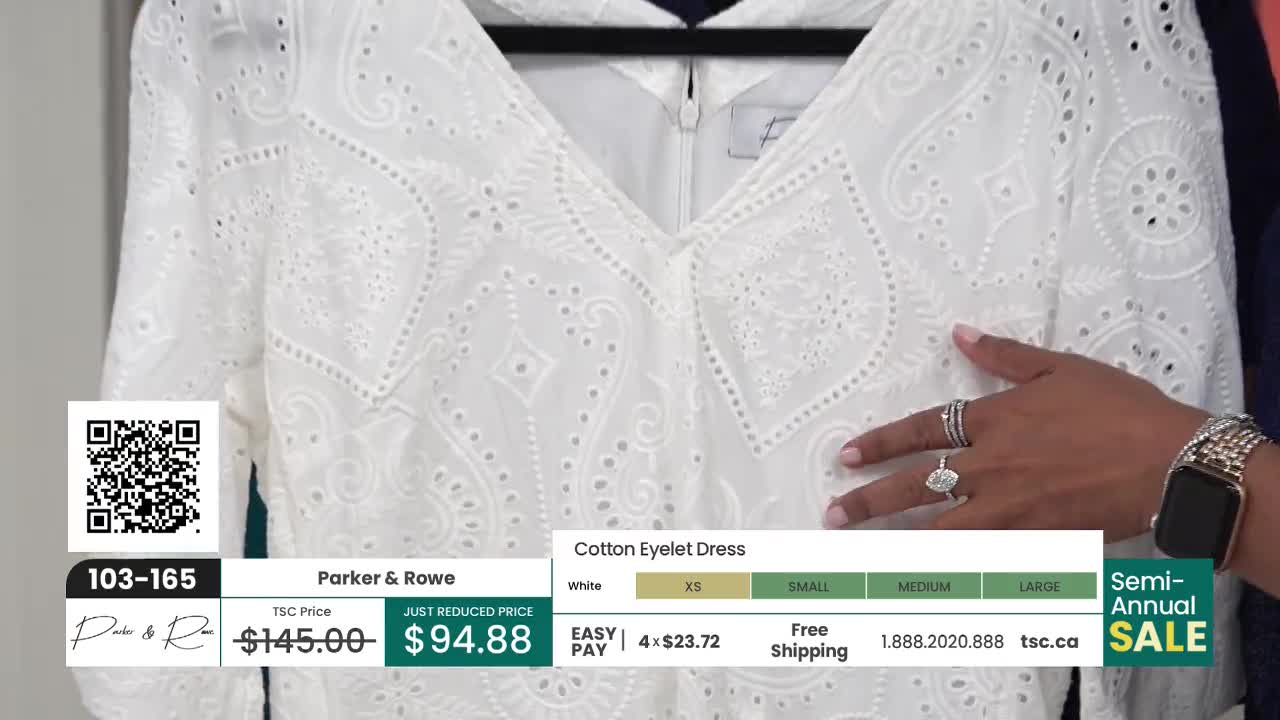 A white eyelet dress hangs on a black hanger, and a hand gently touches the fabric. The TSC price is displayed on the screen, highlighting the reduced price.
