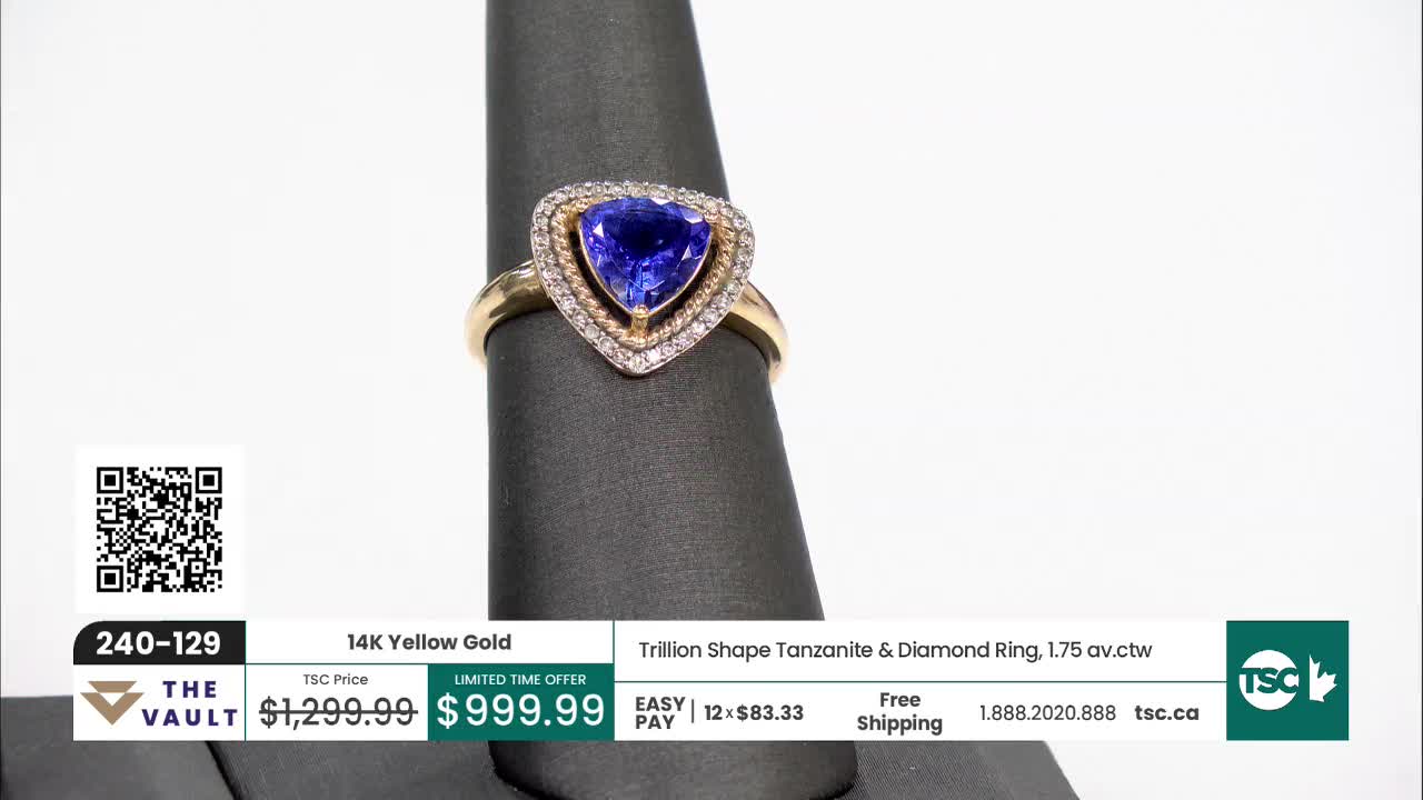 A gold ring with a heart-shaped blue gemstone sits on a black stand. The TSC Canada logo and price are displayed below.
