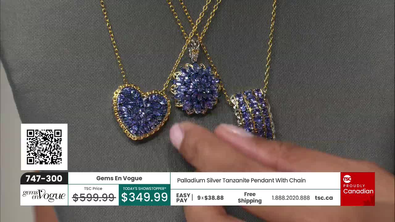 Three gold necklaces with blue-purple pendants hang against a gray backdrop. A hand is gently touching one of the pendants, likely on a TSC segment.

