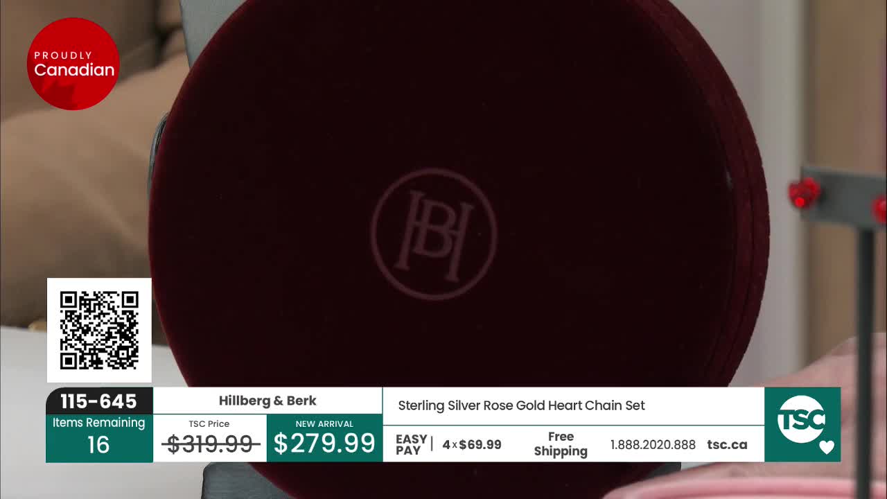 A large, dark red jewelry box sits prominently in the foreground, its lid embossed with the "HB" logo. To the right, a display shows a pair of small, red heart-shaped earrings.