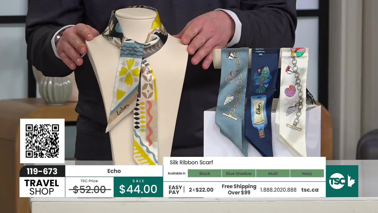 A hand adjusts a mannequin displaying a colorful silk scarf with geometric patterns. Beside it, four other scarves hang, each featuring a different nautical-themed design.