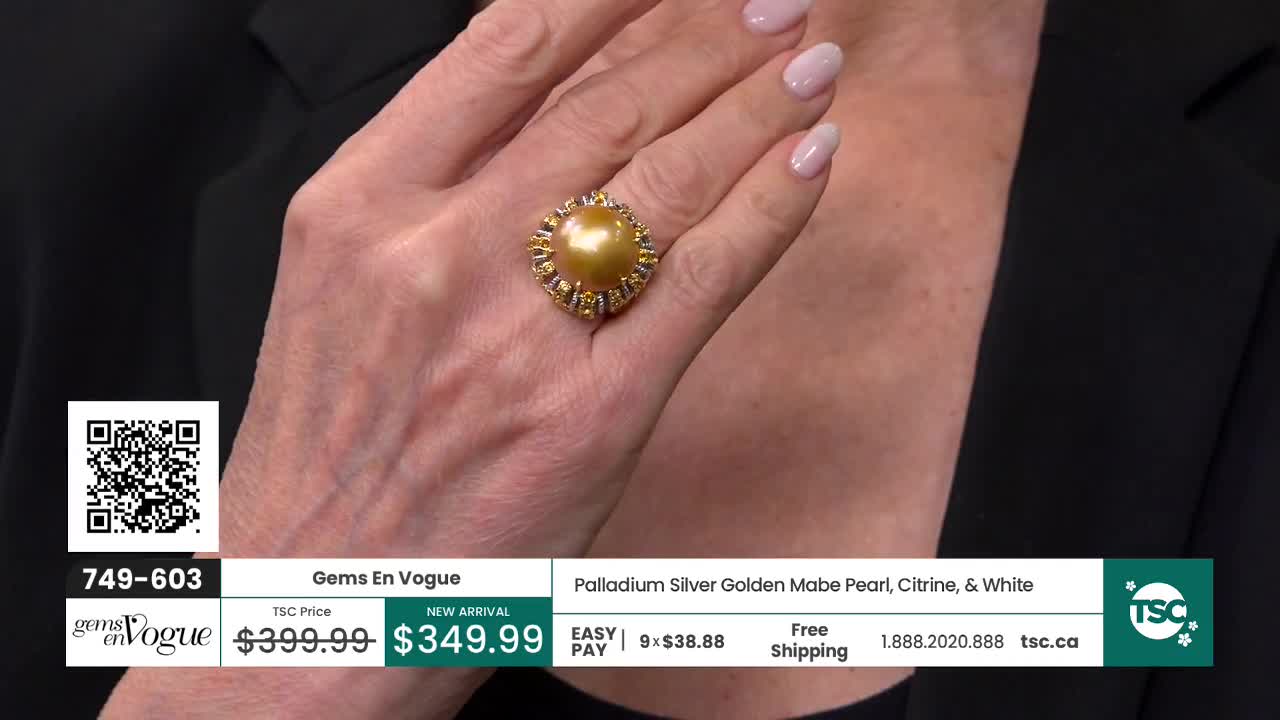 A hand displays a large, golden pearl ring surrounded by small, sparkling stones. The ring is presented on a Canadian shopping channel.