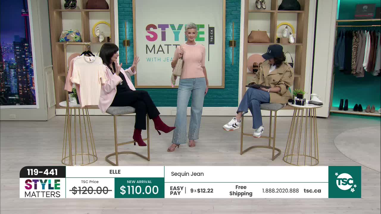 A woman in a pink top and light blue jeans stands center stage, showcasing the "Sequin Jean." To her left, a woman in a black outfit gestures animatedly, while to her right, another woman in a trench coat consults a tablet.