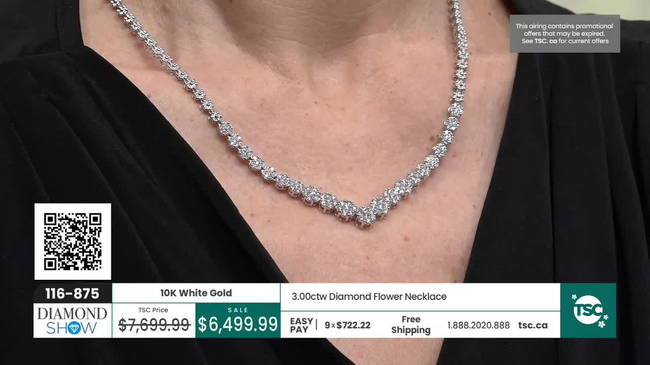 A delicate diamond necklace rests on a black garment. The necklace, crafted from 10K white gold, features a V-shaped design with numerous sparkling stones.