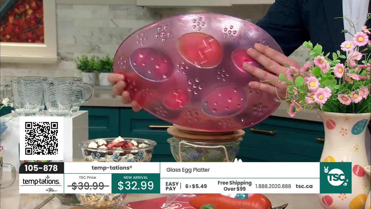 A hand holds up a translucent pink platter shaped to hold eggs. The platter is decorated with raised dots and has six indentations for eggs, some of which are visible. A hand holds up a translucent pink platter shaped to hold eggs. The platter is decorated with raised dots and has six indentations for eggs, some of which are visible.