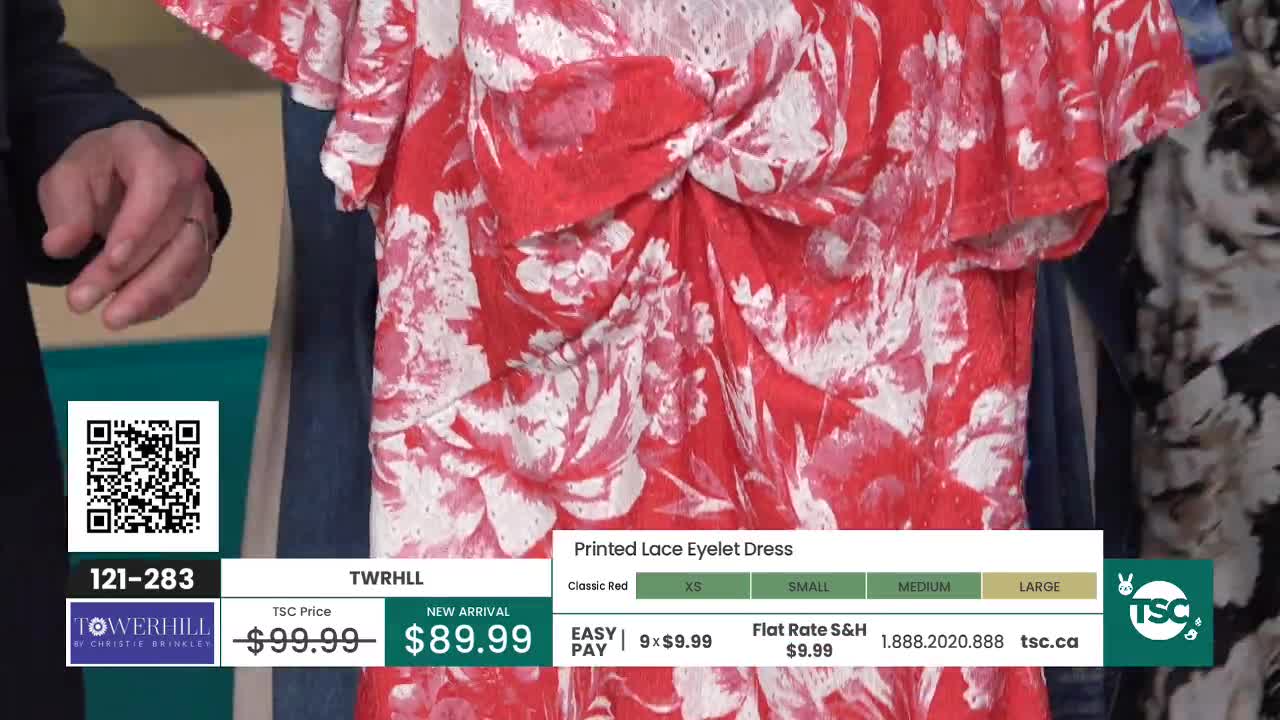 A model displays a vibrant red dress with a white floral print. The dress has a textured, eyelet fabric and a gathered detail at the bodice. A model displays a vibrant red dress with a white floral print. The dress has a textured, eyelet fabric and a gathered detail at the bodice.