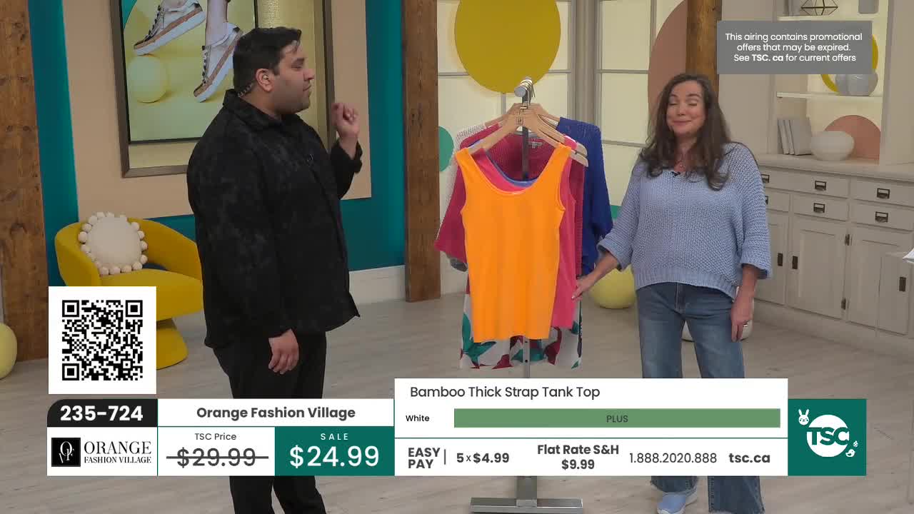 A man in a black shirt gestures with his right hand while standing near a yellow chair. A woman in a blue sweater and jeans smiles, holding onto a rack of colorful tank tops. A man in a black shirt gestures with his right hand while standing near a yellow chair. A woman in a blue sweater and jeans smiles, holding onto a rack of colorful tank tops.