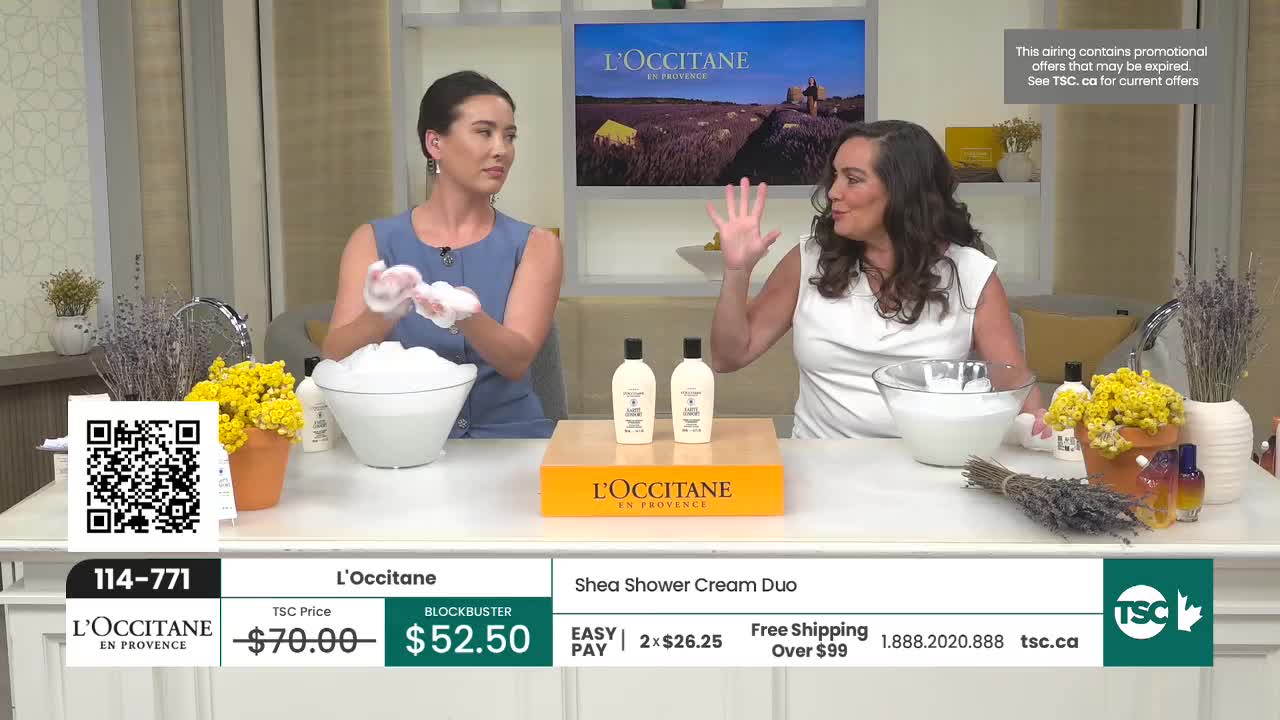 Two women are demonstrating L'Occitane Shea Shower Cream on TSC. One woman holds a bowl overflowing with white foam, while the other gestures with her hand. Two women are demonstrating L'Occitane Shea Shower Cream on TSC. One woman holds a bowl overflowing with white foam, while the other gestures with her hand.