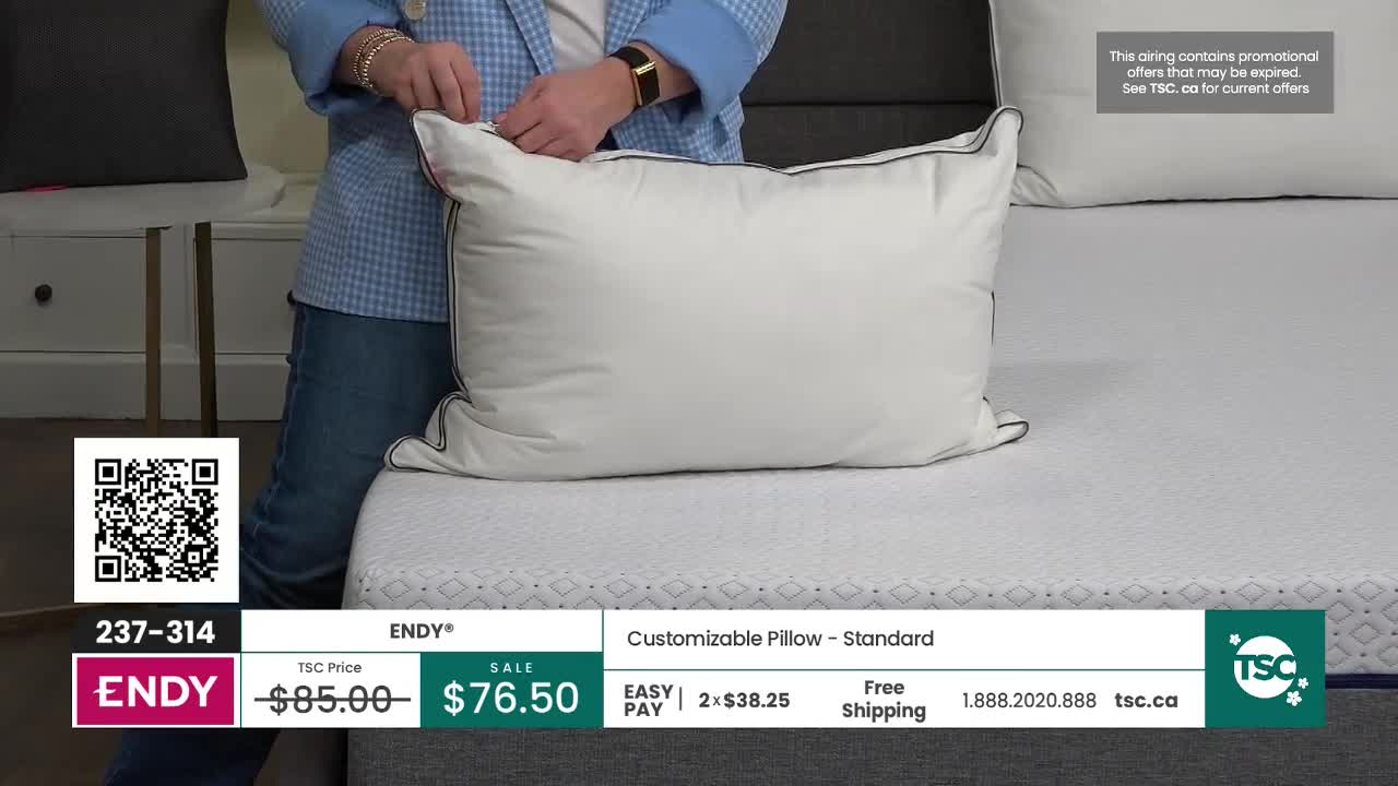A person is adjusting the zipper on a large white pillow. The pillow rests on a textured mattress, with another pillow visible behind it.