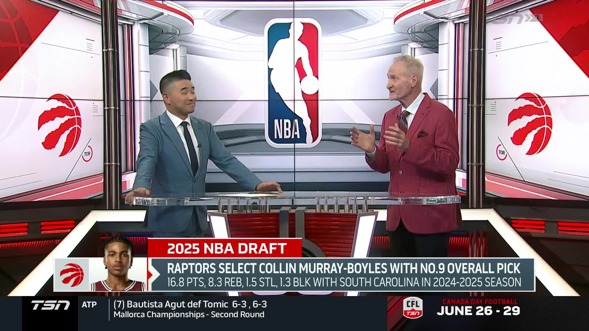 Two men in suits are discussing the NBA draft on a TSN1 set, with a graphic displaying player stats. The man in the red blazer gestures with his hands, while the other man listens.
