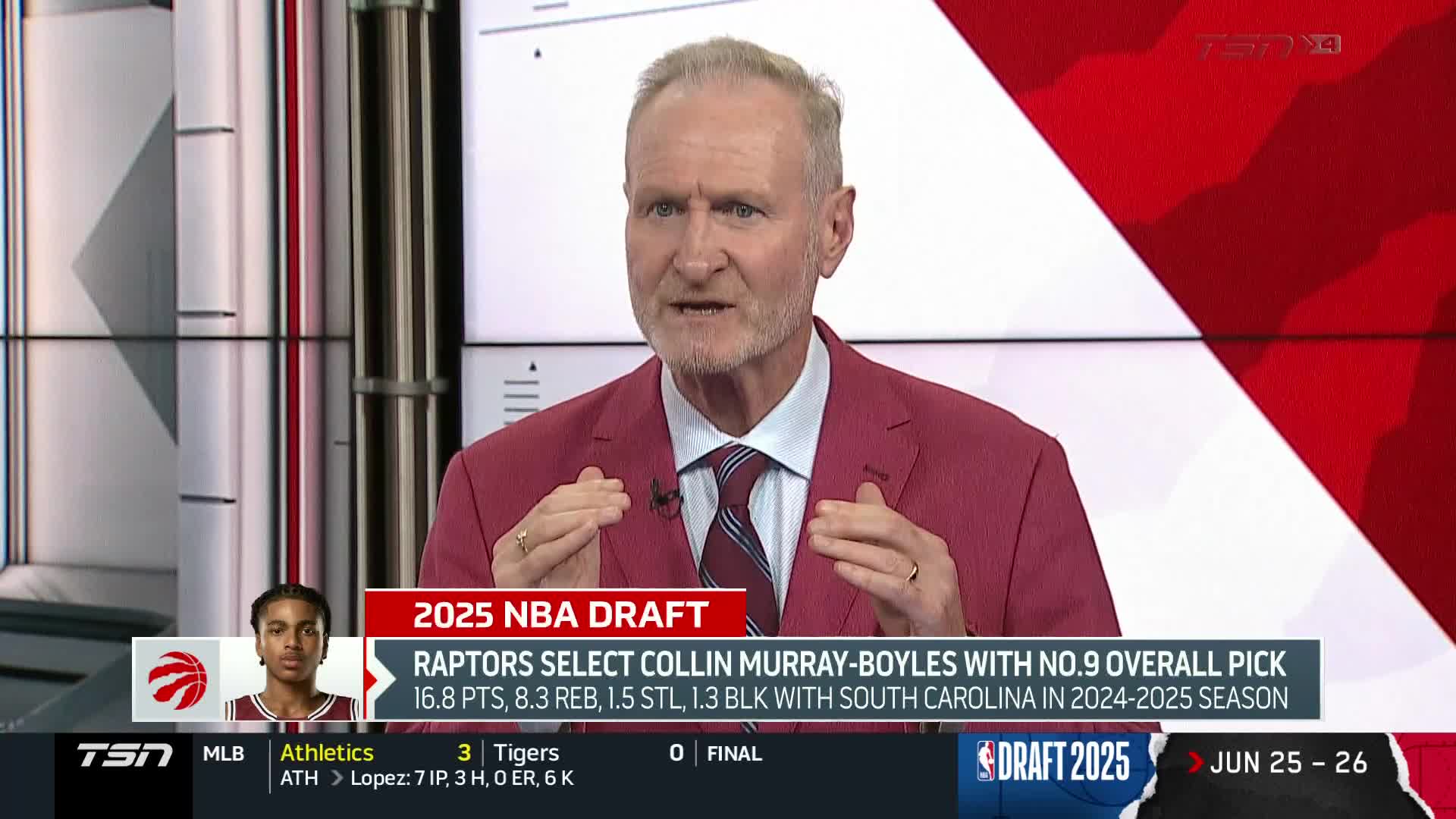 A man in a pink suit, likely on TSN4 in Canada, gestures with his hands while discussing the Raptors' draft pick. Below him, the screen displays details about the selection of Collin Murray-Boyles.
