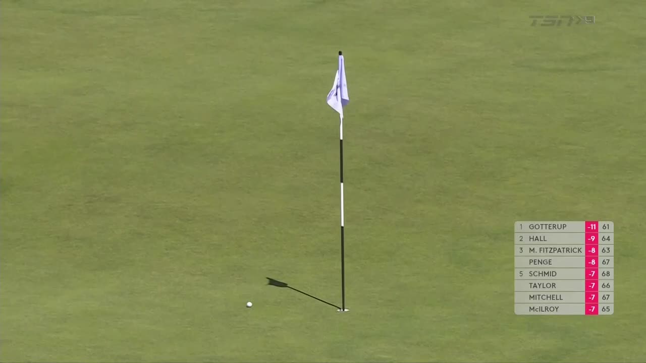 The flag flutters gently in the breeze, casting a long shadow across the green. A white golf ball sits near the hole, with the leaderboard on TSN5 showing the standings.
