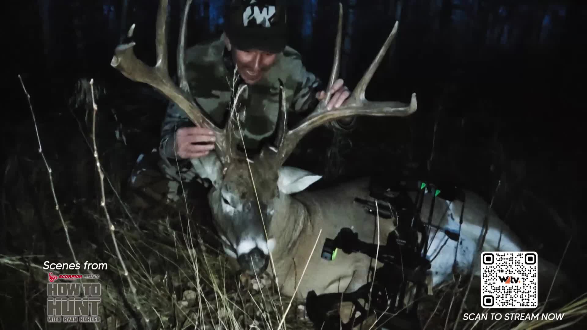 A hunter proudly displays a massive buck he just harvested in the Canadian wilderness. His compound bow rests beside the impressive rack of antlers. A hunter proudly displays a massive buck he just harvested in the Canadian wilderness. His compound bow rests beside the impressive rack of antlers.