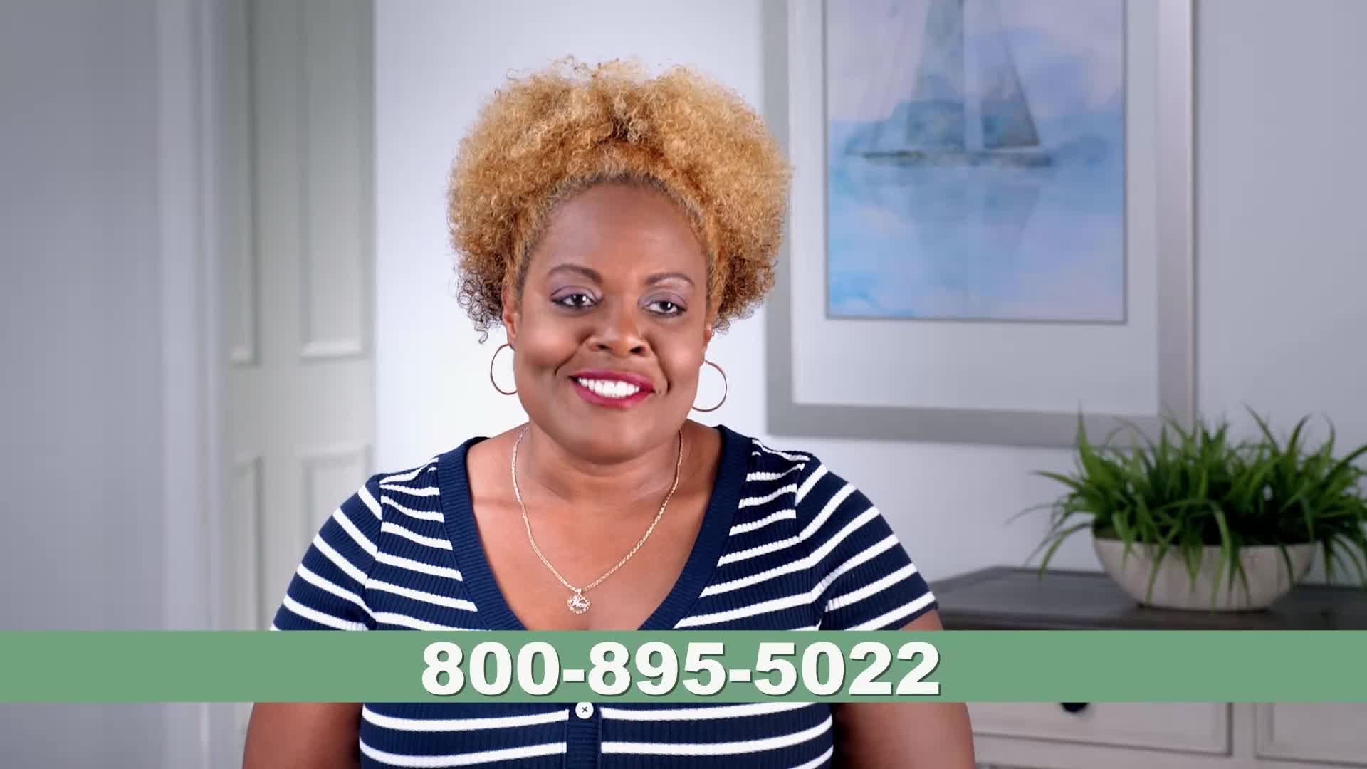 A woman with bright, curly hair smiles directly at me, her navy and white striped shirt a familiar sight from Wild TV. A green bar displays a phone number, 800-895-5022, across the bottom of the screen.