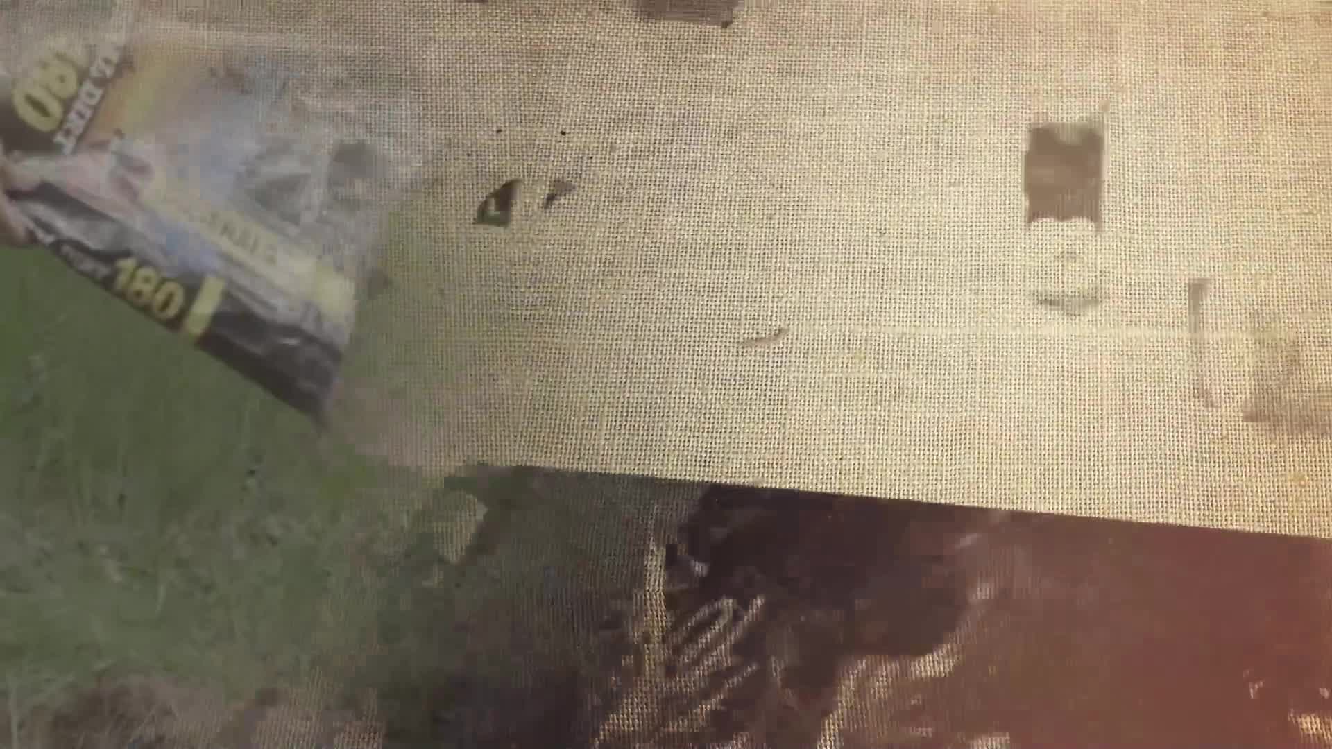 A yellow and black bag, labeled "180," tumbles through the air. It's being tossed into a patch of green grass.