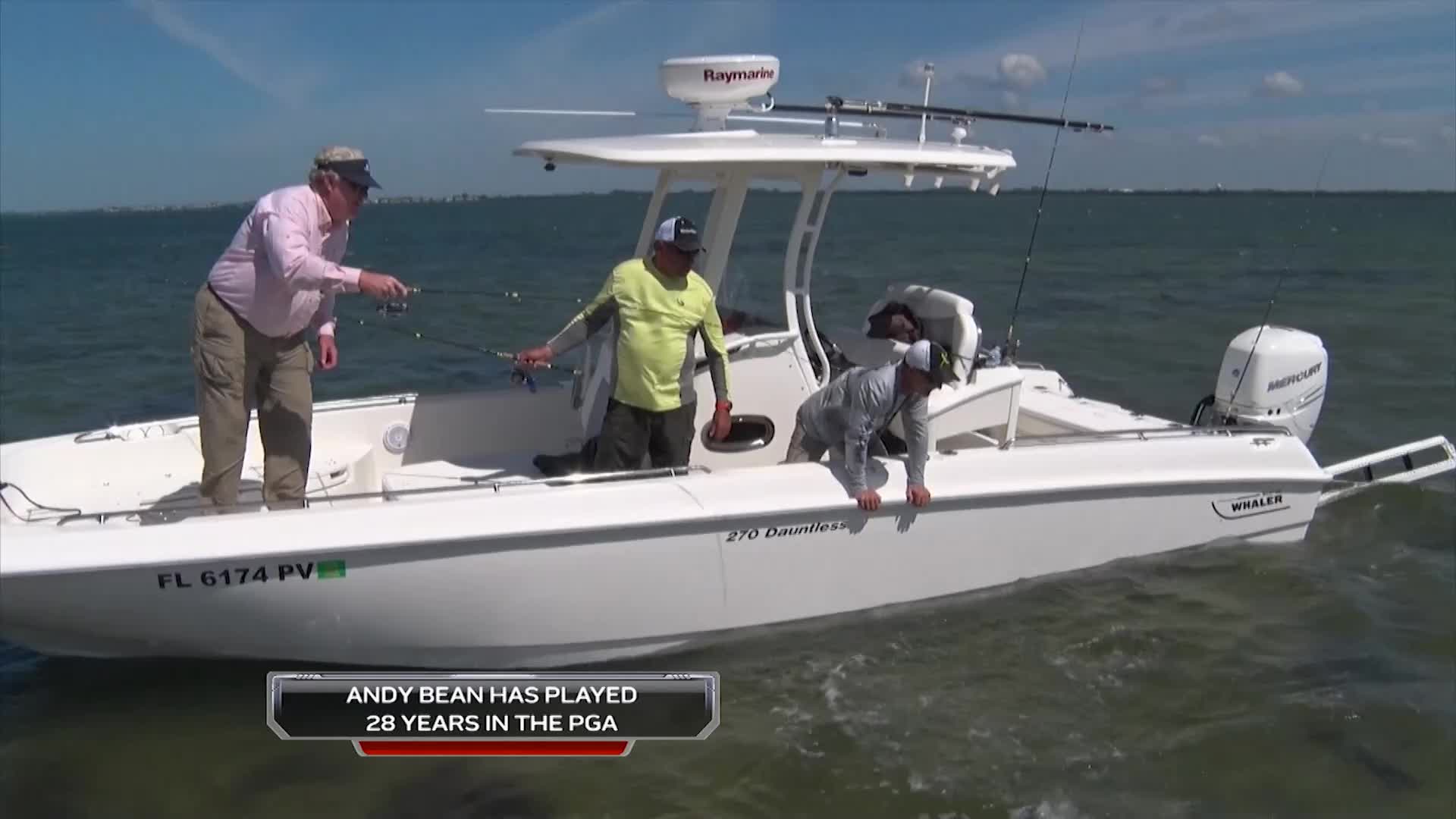 A man in a pink shirt casts his fishing line from the bow of a boat. Two other men are also on the boat, one in a bright yellow shirt and another in a grey long-sleeved shirt, all enjoying a day on the water.