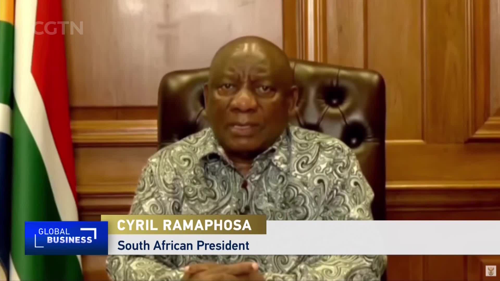 Cyril Ramaphosa, the South African President, is speaking directly to the camera, his image broadcast on CGTN's "Global Business." Behind him, the South African flag stands alongside wooden paneling.
