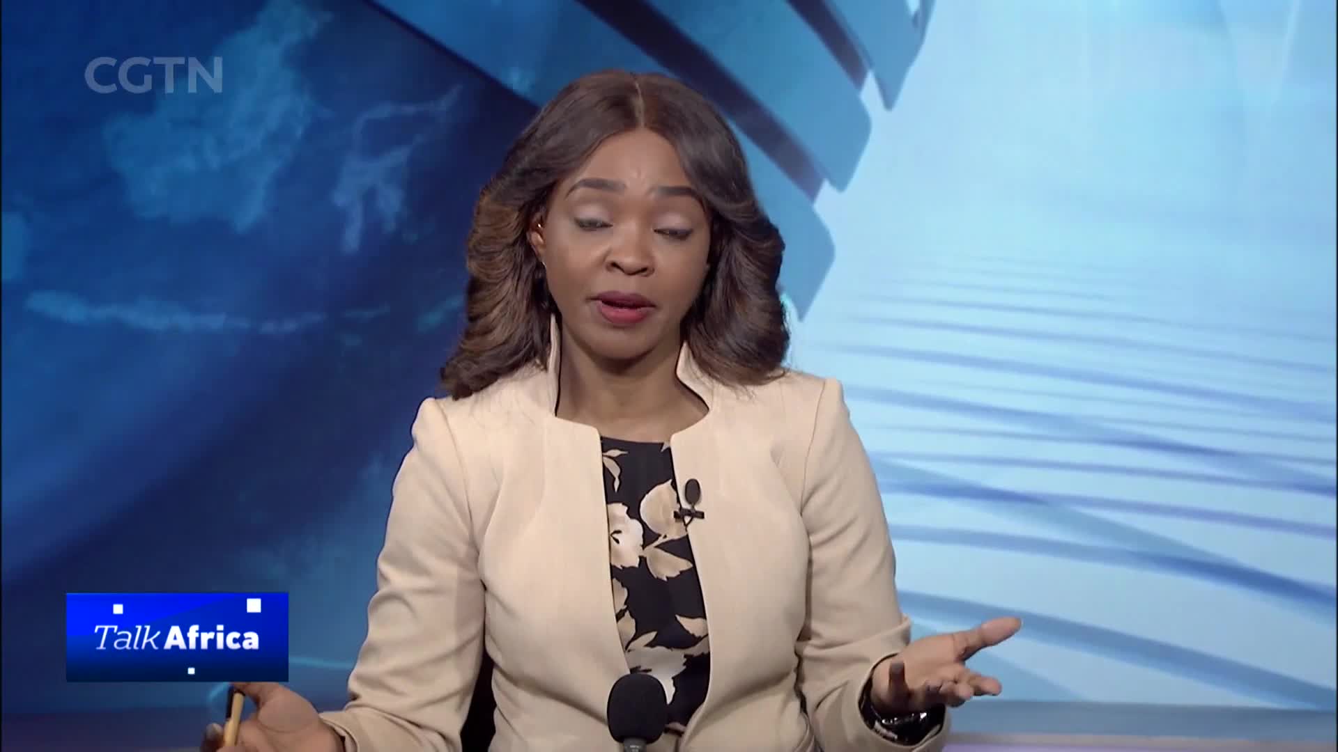 A woman in a tan blazer speaks animatedly, gesturing with her hands. The CGTN logo and "Talk Africa" graphic appear in the lower left corner.