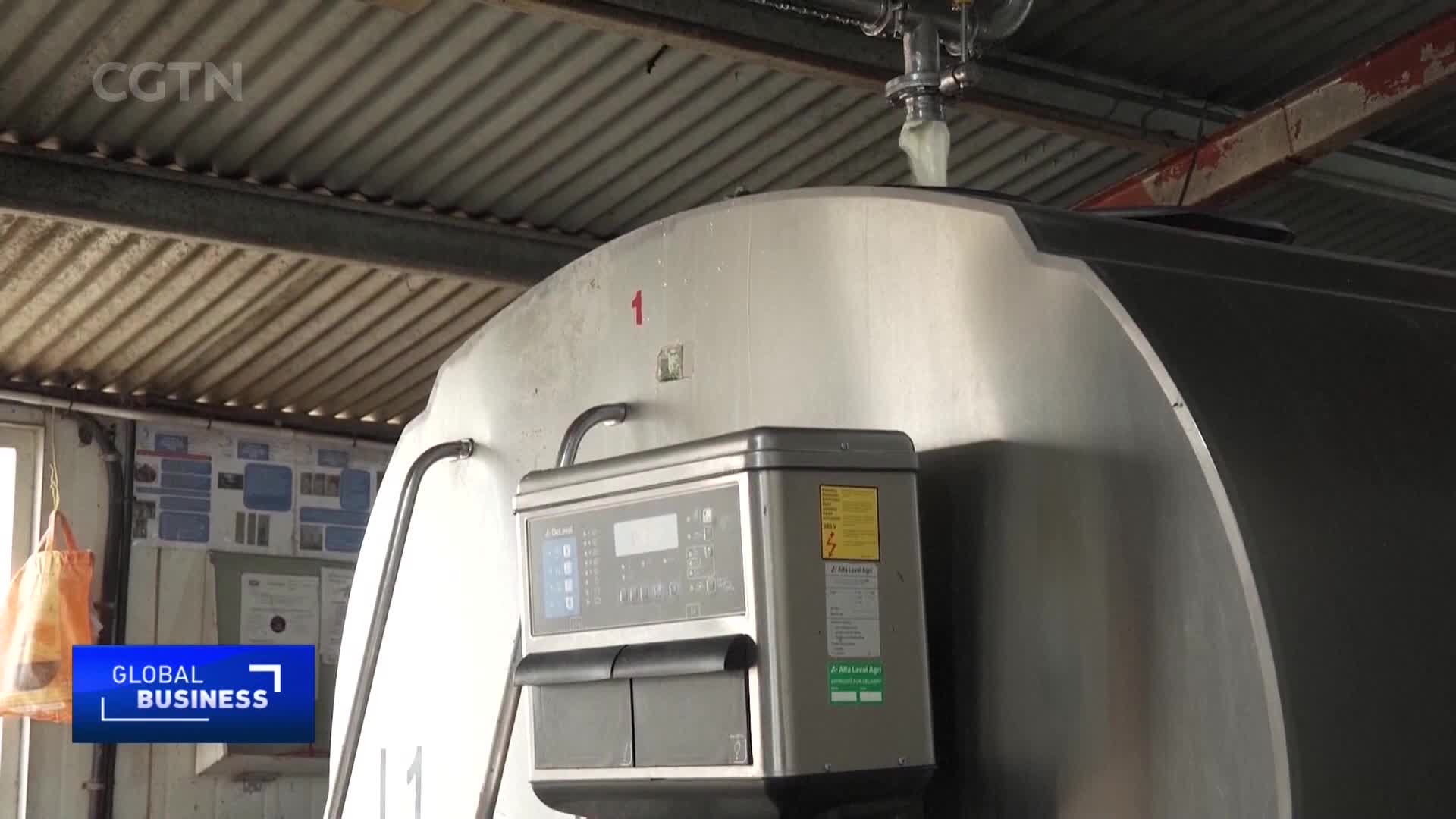 A thick, white substance is being pumped into a large, silver tank. The CGTN Global Business logo appears in the lower left corner. A thick, white substance is being pumped into a large, silver tank. The CGTN Global Business logo appears in the lower left corner.