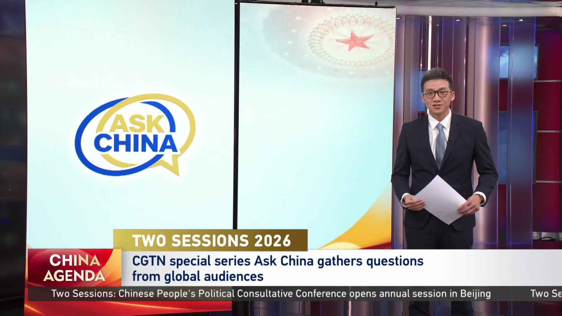 A man in a suit stands holding papers, facing the camera. Behind him, a screen displays the "Ask China" logo and text about CGTN's special series.