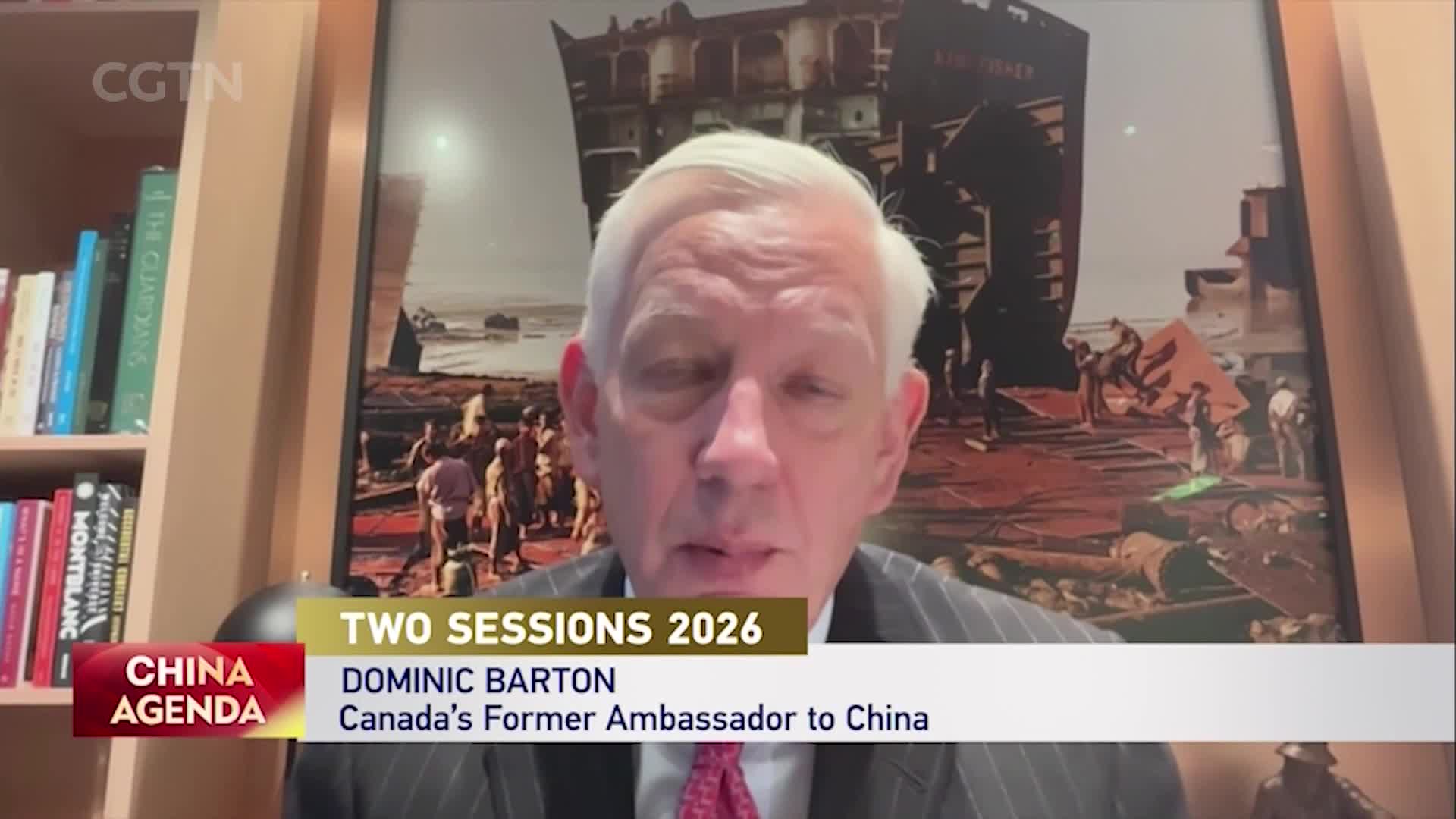 Dominic Barton, Canada's former ambassador to China, speaks during a CGTN broadcast on the "China Agenda." A large painting behind him depicts a scene of workers dismantling a ship.