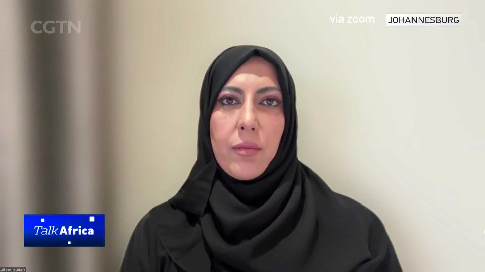 A woman in a black hijab looks directly forward, her makeup noticeable. The "Talk Africa" logo appears in the lower left corner, and "via zoom JOHANNESBURG" is displayed at the top right.