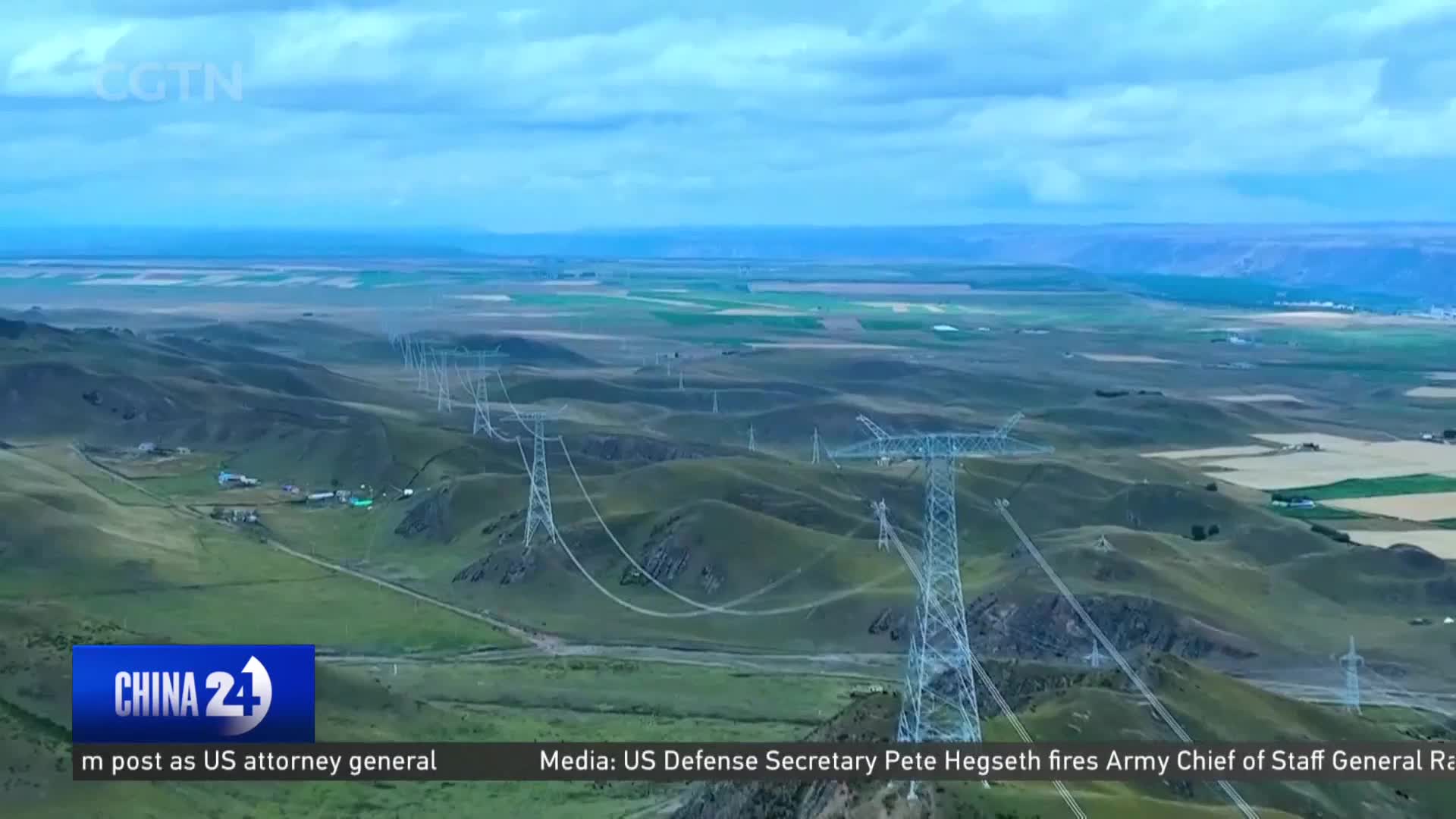 Towering pylons march across the rolling green hills, their wires strung taut against the vast Chinese sky. Farther off, patchwork fields stretch towards a distant horizon. Towering pylons march across the rolling green hills, their wires strung taut against the vast Chinese sky. Farther off, patchwork fields stretch towards a distant horizon.