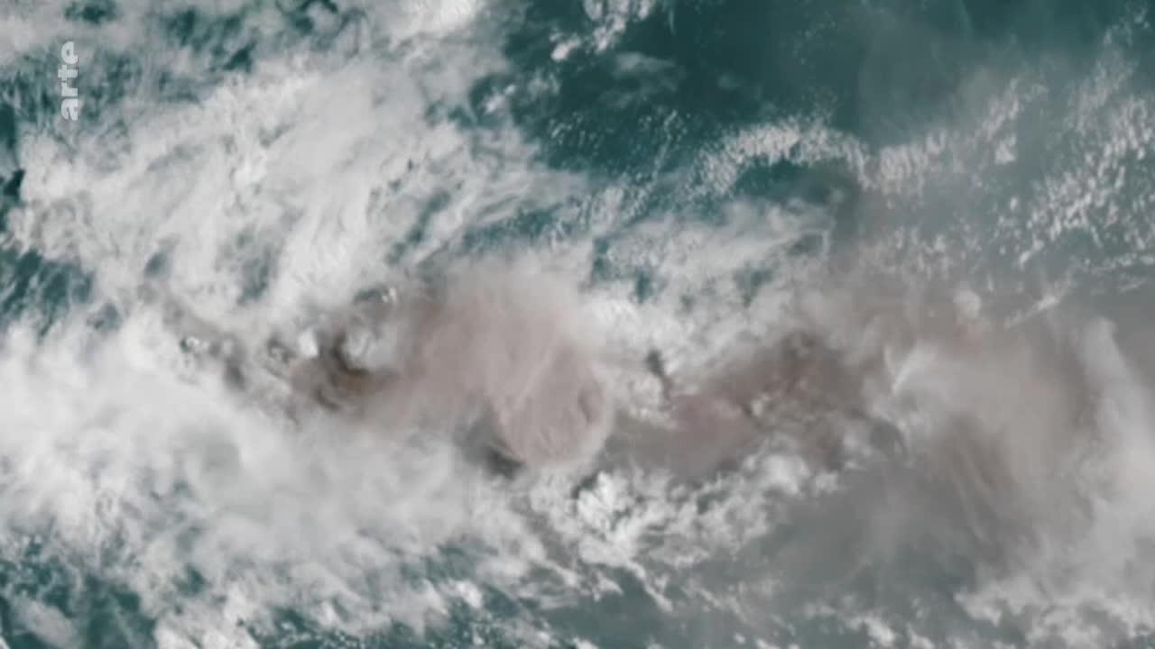 A large, ashy cloud billows across the sky, its edges blending into the surrounding white formations. The scene, captured by arte, shows the raw power of nature.
