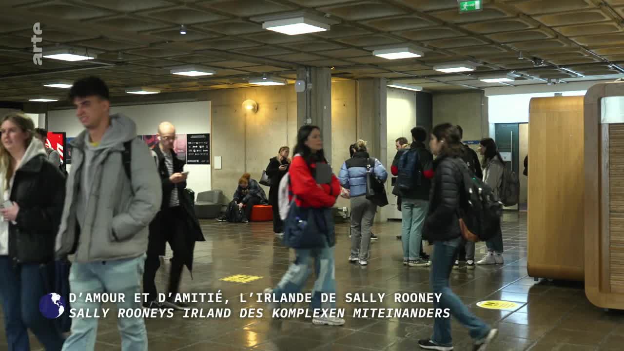 People in jackets and hoodies are walking through a wide, concrete hallway. The arte logo is in the corner, and text about Sally Rooney's Ireland is overlaid on the scene.
