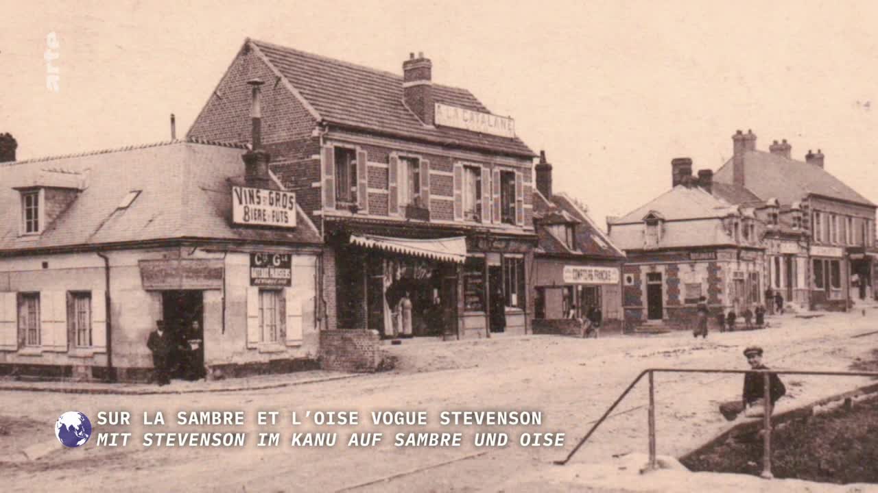 A quiet street in a French town is lined with buildings, including a shop with a striped awning. A few figures stand near the buildings, and a young boy sits on a low wall in the foreground.
