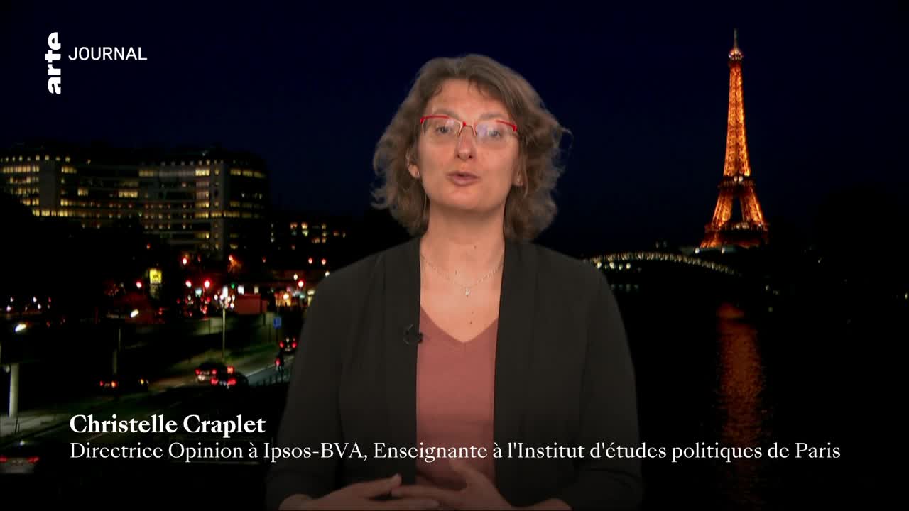The Eiffel Tower glows orange against the dark Parisian sky. A woman speaks directly to the camera, her name and title displayed below her.