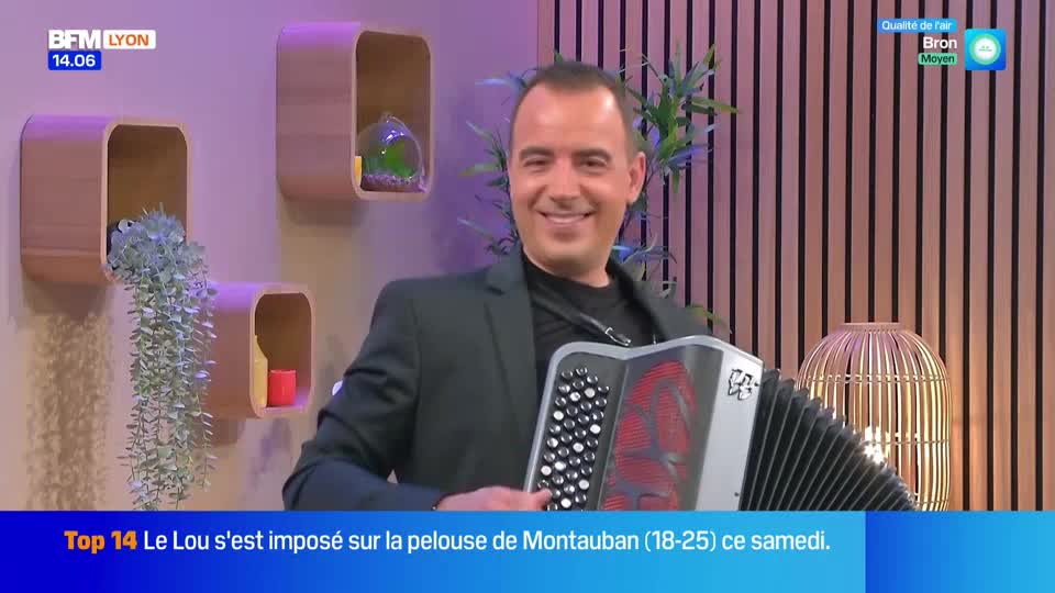 A man in a suit smiles directly at the camera, holding an accordion. The BFM Lyon logo is visible in the top left corner.
