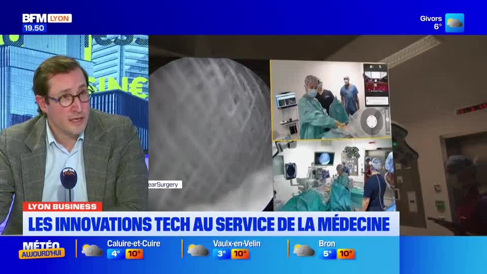 A man in a suit and glasses speaks into a microphone, while on screen, surgeons in scrubs work in an operating room. Medical imaging displays fill the background, showing intricate details of internal procedures. A man in a suit and glasses speaks into a microphone, while on screen, surgeons in scrubs work in an operating room. Medical imaging displays fill the background, showing intricate details of internal procedures.