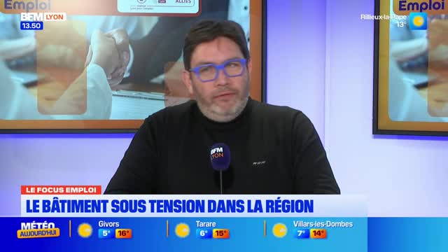 A man with blue-rimmed glasses is speaking into a microphone on a BFM Lyon broadcast. A graphic behind him reads "LE BÂTIMENT SOUS TENSION DANS LA RÉGION." A man with blue-rimmed glasses is speaking into a microphone on a BFM Lyon broadcast. A graphic behind him reads "LE BÂTIMENT SOUS TENSION DANS LA RÉGION."