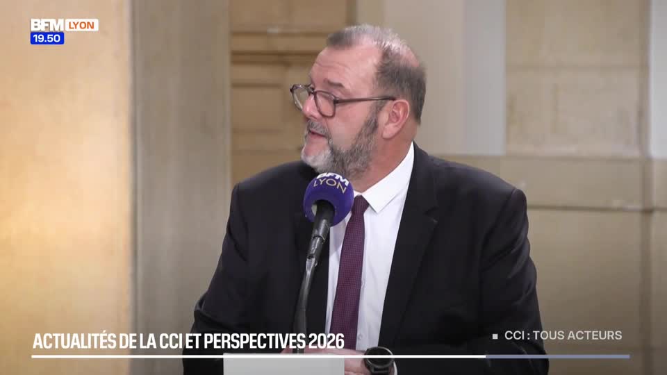 A man in a suit speaks into a microphone, his glasses reflecting the light. The BFM Lyon logo is visible in the corner, along with text about "Actualités de la CCI et Perspectives 2026." A man in a suit speaks into a microphone, his glasses reflecting the light. The BFM Lyon logo is visible in the corner, along with text about "Actualités de la CCI et Perspectives 2026."