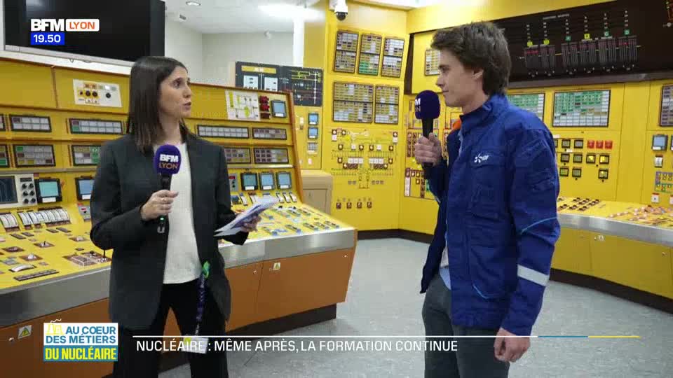 A woman holding a microphone and papers speaks with a young man in a blue jacket. They stand before a wall of yellow control panels, a scene from a BFM Lyon report on nuclear training.
