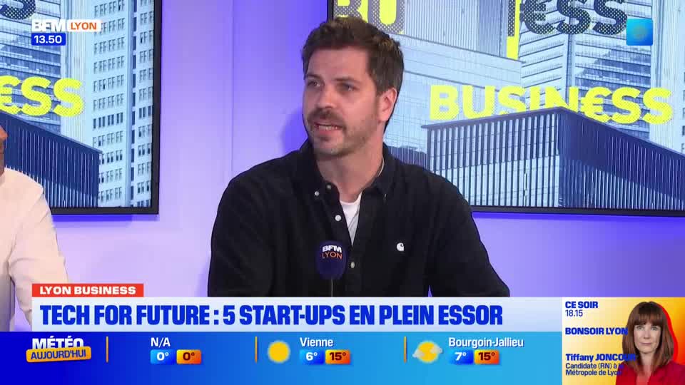 A man with a beard, wearing a dark shirt, speaks into a microphone on a BFM Lyon set. Behind him, a screen displays "BUSINESS" in large yellow letters.