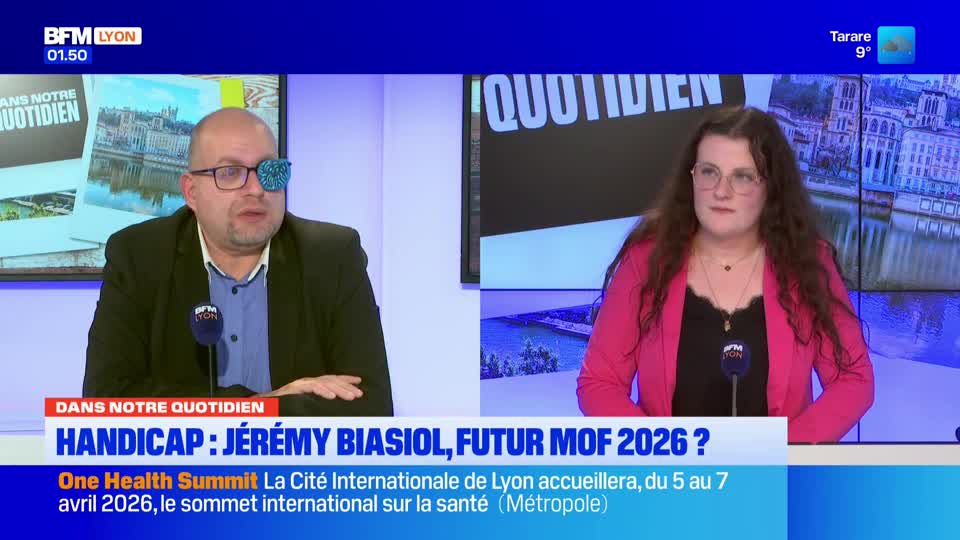 A man with a shimmering patch over his eye speaks into a microphone. Across from him, a woman in a bright pink jacket listens intently.